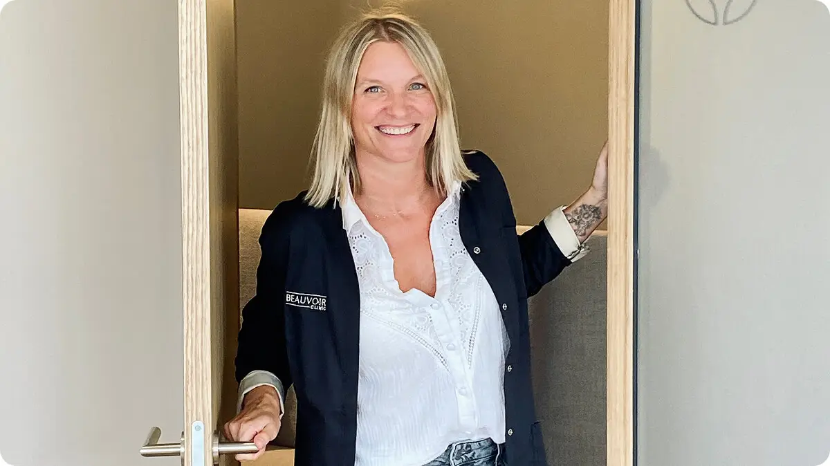 Femme souriante ouvrant la porte d'une clinique