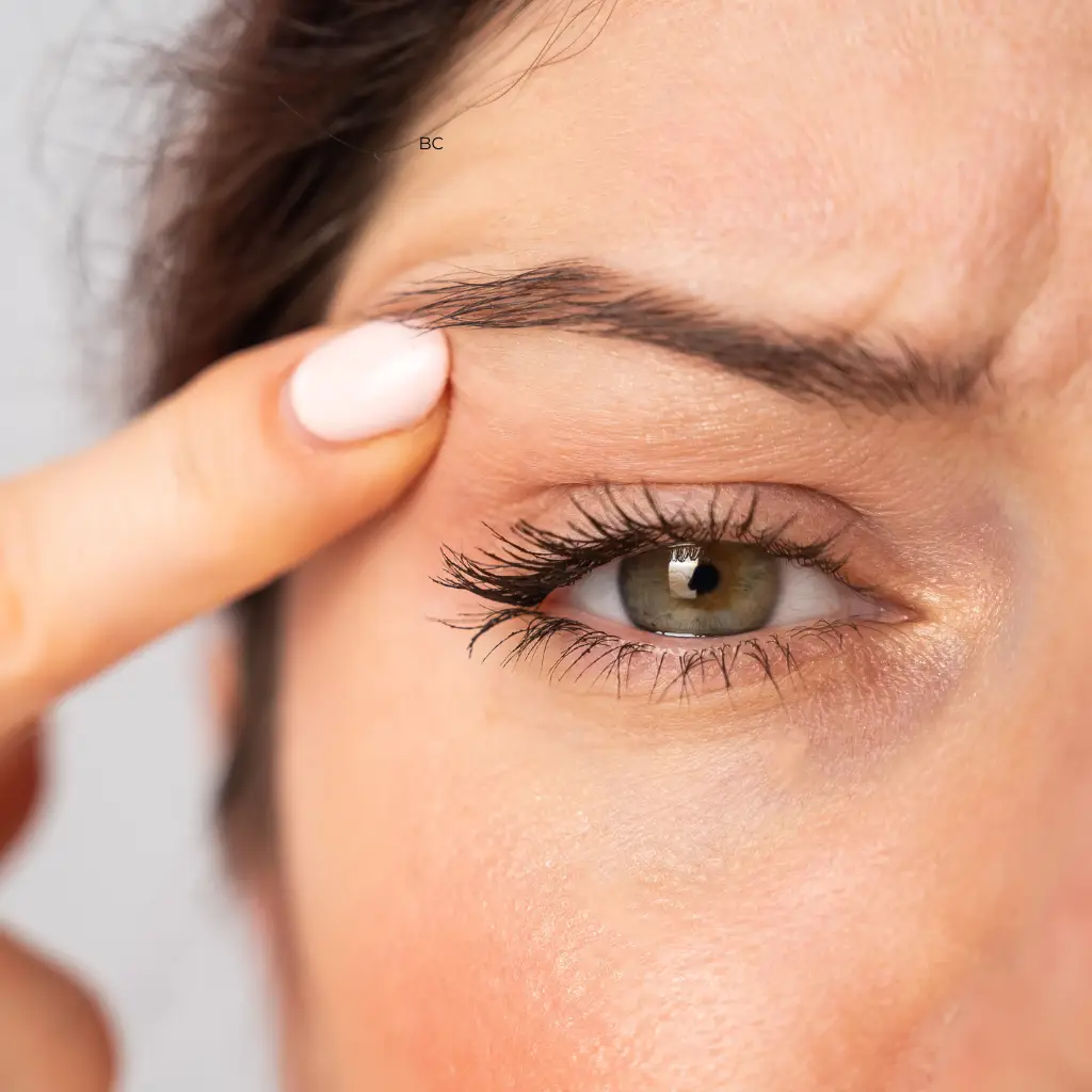 Femme touchant sourcil près de l’œil